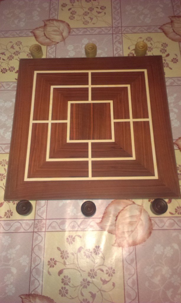 A Nine Men's Morris board and pieces before a game begins.